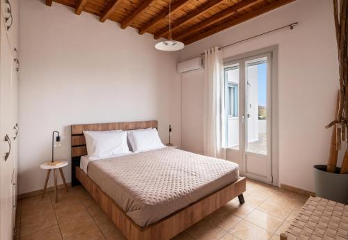 a bedroom with a bed and a glass door at Hillside Collection - by Hospirit in Mikonos