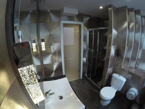 a bathroom with a toilet and a shower and a sink at Carol Hotel in Piraeus