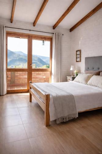 a bedroom with a large bed and a large window at Villa Luz Hotel in Silvia