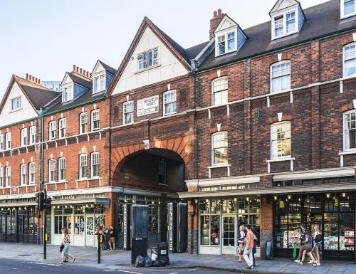 a large brick building with people walking in front of it at 2 Bed Liverpool Street Loft in London