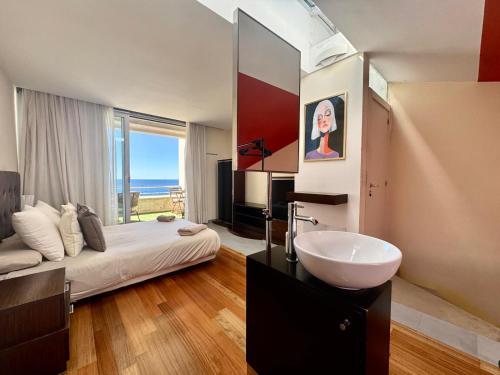 ein Badezimmer mit Waschbecken, Bett und Spiegel in der Unterkunft VILA TABARCA QUALITY & LUXURY in Tabarca