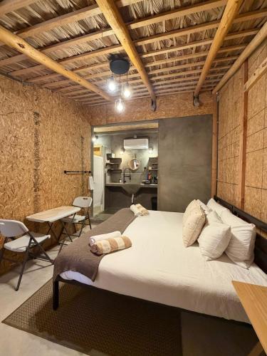 a bedroom with a large bed and a table and chairs at Salty Sun Cabins Bahía Turquesa in La Ventana