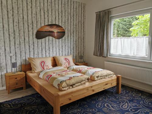 a bedroom with a bed with pillows and a window at Ferienwohnung 1 Nordsee Gulfhof Dornum - mit großem Garten in Roggenstede