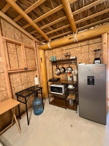 a kitchen with a refrigerator and a table in a room at Salty Sun Cabins Bahía Turquesa in La Ventana