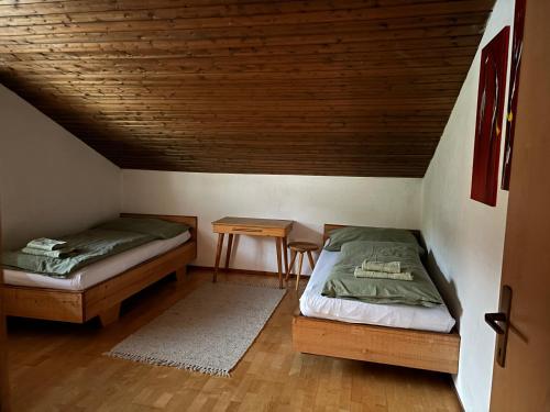 a room with two beds and a table in a attic at Appartement Blickfang in Bruck an der Mur