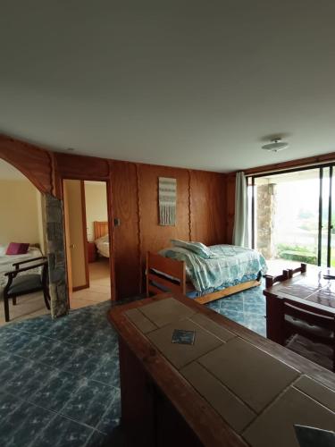 a bedroom with a bed and a table and a window at Strandvagen Maitencillo in Maitencillo