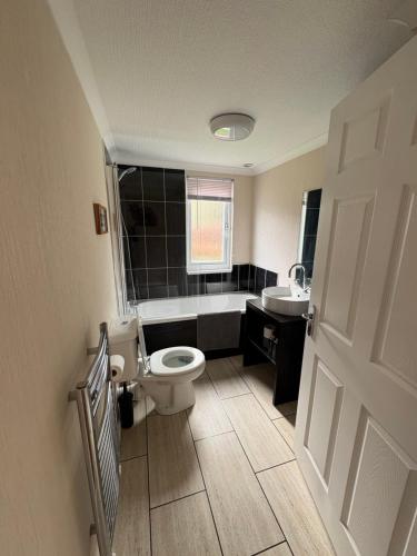 a bathroom with a toilet and a tub and a sink at caddys lodge in Tydd Saint Giles