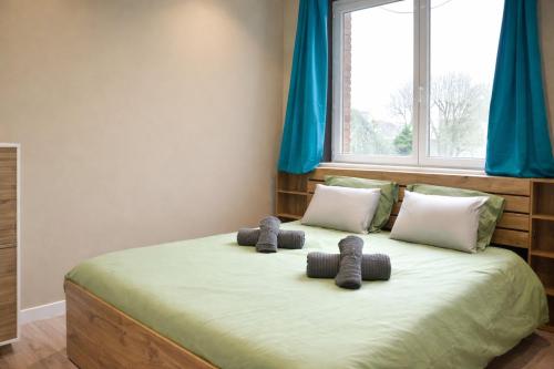 a bedroom with a bed with two stuffed animals on it at Le 5 Place Carnot in Douai