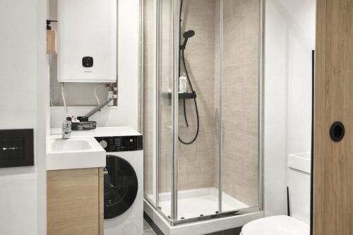a bathroom with a shower and a washer and dryer at Le 5 Place Carnot in Douai