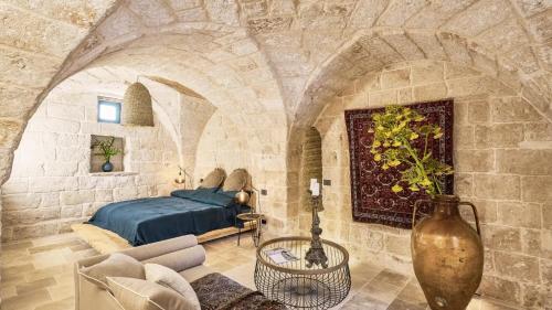 a bedroom with a bed in a stone wall at Bambarone L'Agriturismo in Fasano