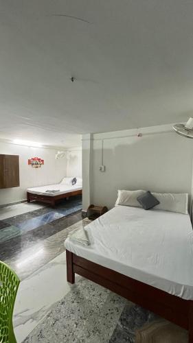 a bedroom with a bed and a chair in it at swagatom Homestay in Jorhat