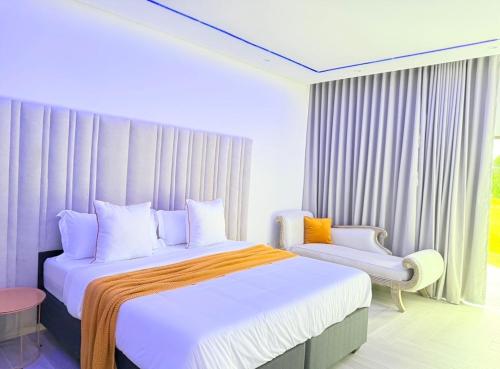 a bedroom with a large bed and a chair at Golfview luxury apartment in Richards Bay