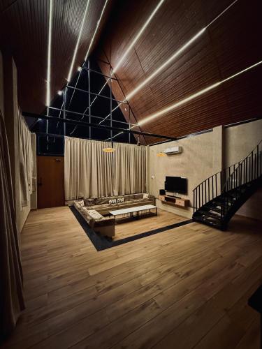 a large room with a couch and a stage at Neora Farms in Simrol