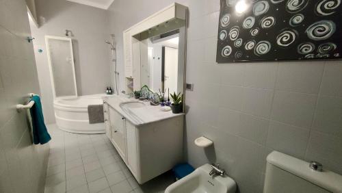 a bathroom with a sink and a toilet and a mirror at Casa Mario in Loano