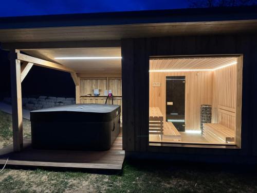 a screened in porch with a hot tub on a deck at VándorLÓ Vendégház in Komló