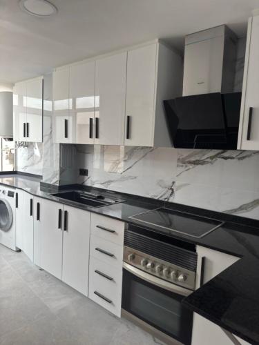 a kitchen with white cabinets and a stove top oven at Apartamento Dúplex vacacional in Burriana