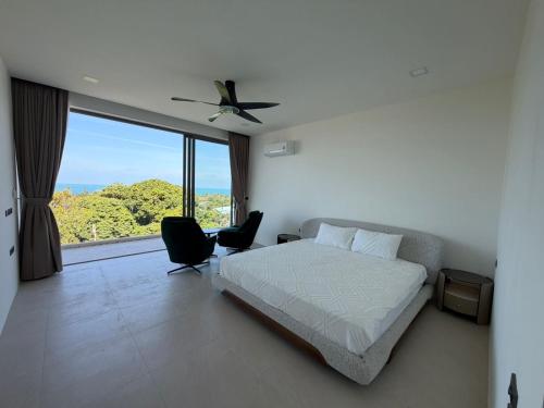a bedroom with a bed and a large window at Villa luxurious in Koh Samui