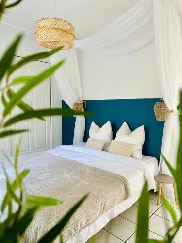 a bedroom with a bed with a blue wall at Le Cottage de L&M in Sigean