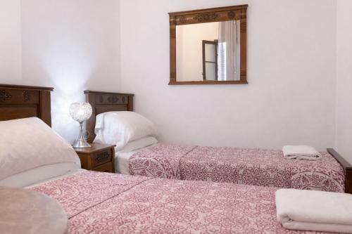 two beds in a room with a mirror at Tangier city center 3 in Tangier