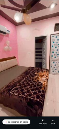 a bedroom with a bed in a room with pink walls at Platinum hotel in Bhucho