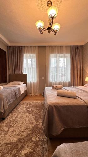 a hotel room with two beds and a chandelier at Guest House Melissa in Duisi