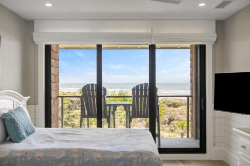 a bedroom with a bed and a view of the ocean at 2371 Shipwatch Villa by Akers Ellis Rentals in Kiawah Island