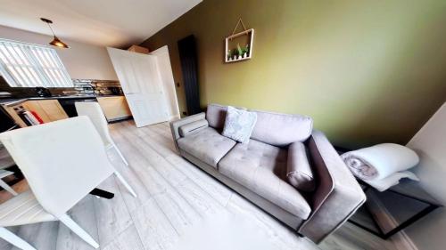 a living room with a couch and a kitchen at Simply The Bay - Part of the The Bay Filey Holiday Village with pool, gym and direct beach access, pub, restaurant, tennis and meadows walks in Filey