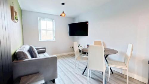 a living room with a table and a couch at Simply The Bay - Part of the The Bay Filey Holiday Village with pool, gym and direct beach access, pub, restaurant, tennis and meadows walks in Filey
