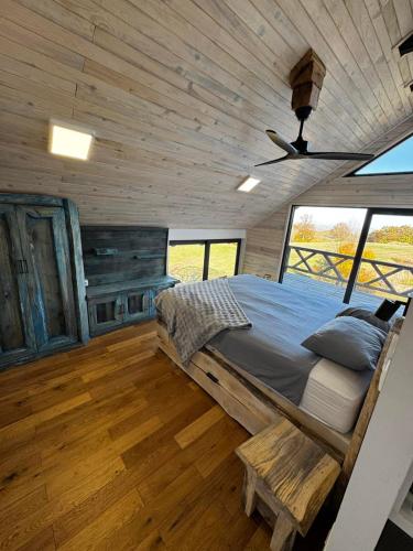 a bedroom in a log cabin with a bed and a ceiling at Sumadijski ranc-Brvnara in Brestovac