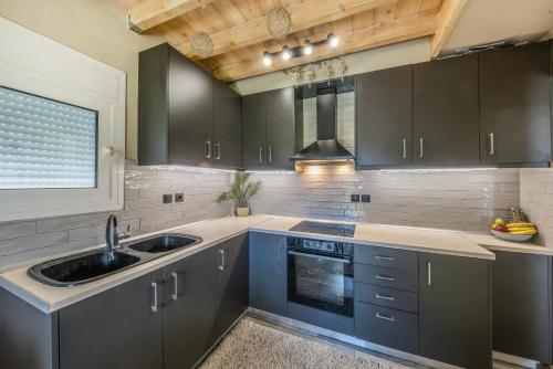 a kitchen with blue cabinets and a sink and a window at Kallistis Home in Kontokali