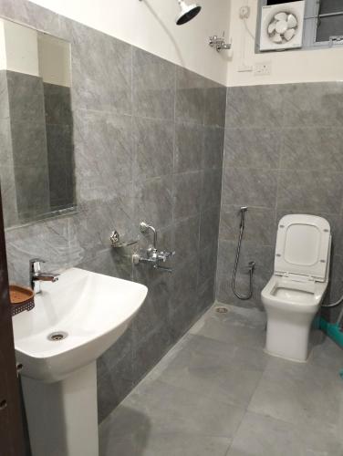 a bathroom with a sink and a toilet at Windfall Homestay in Dimapur
