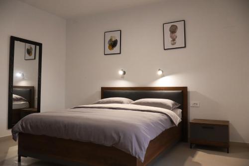 a bedroom with a bed with three pictures on the wall at Velebit Escape Apartments in Starigrad