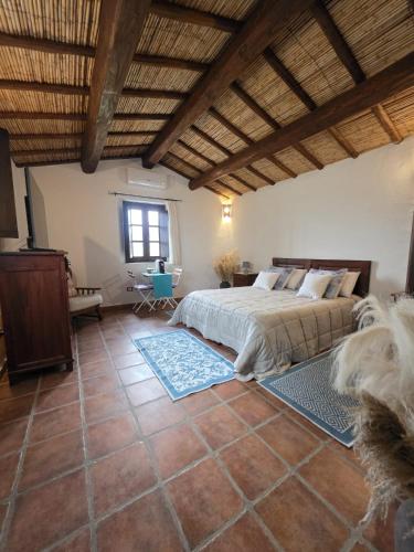 a bedroom with a large bed and a wooden ceiling at Stazzu Barecca B&B in Cugnana Verde