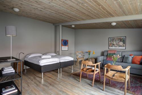 a bedroom with a bed and a couch at Silfurberg in Þorgrímsstaðir