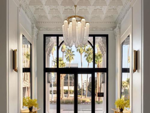 a chandelier hangs above a window in a hallway at Fairmont Breakers Long Beach in Long Beach