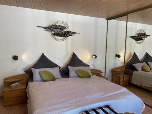a bedroom with a large bed with green pillows at Villa Rose in Seignosse