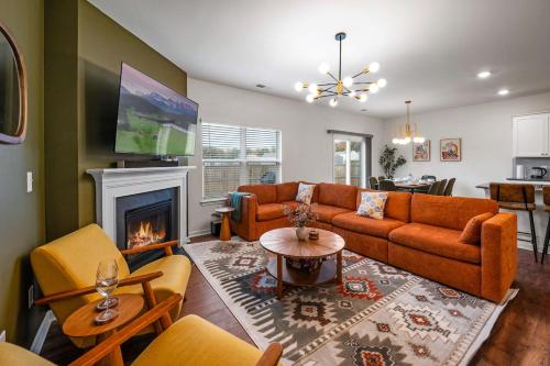 a living room with orange furniture and a fireplace at Spacious Farragut 5BR FamilyGroup Getaway near UT in Knoxville
