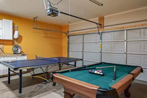 a room with a pool table and two garage doors at Spacious Farragut 5BR FamilyGroup Getaway near UT in Knoxville
