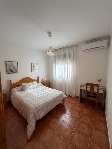 a bedroom with a bed and a table and a chair at Casa Fuenteblanca in Liétor