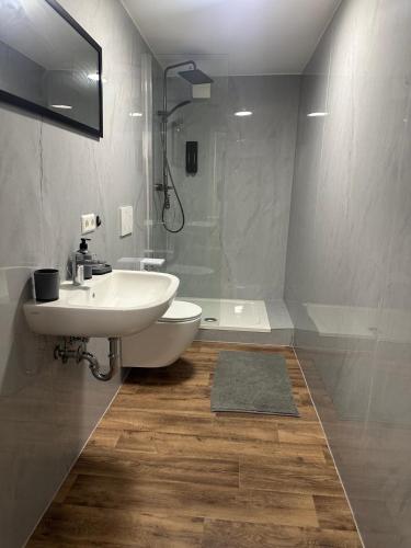 a white bathroom with a sink and a shower at R&B pension in Ichenhausen