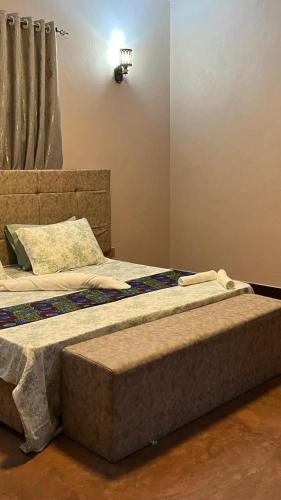 a bedroom with a large bed with a head board at Katojo Quick Rides and stays in Arusha
