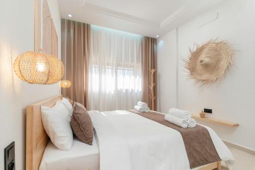 a bedroom with a white bed and a large window at Taghazout Bay Chic Residence Sea View in Tamraght Ouzdar