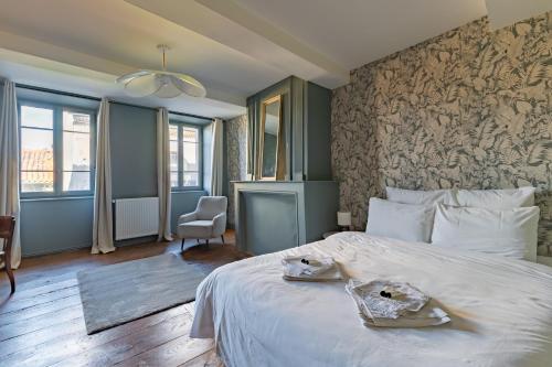 a bedroom with a bed with two towels on it at Casa Miasto - Chambres d'hôtes & Spa in Aspet