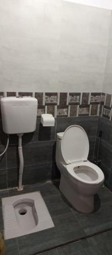 a bathroom with a toilet and a sink at Nursery Suites in Karachi