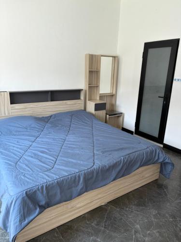 a bedroom with a bed with a blue comforter at SET Guesthouse 3 in Kata Beach