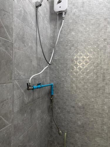 a shower in a bathroom with a phone on the wall at SET Guesthouse 3 in Kata Beach