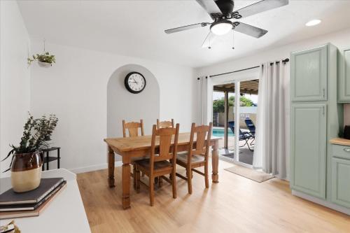 a dining room with a table and a clock on the wall at Phoenix Getaway, Poolside Oasis, & Tesla Charger in Phoenix