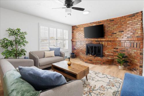 a living room with a couch and a brick wall at Phoenix Getaway, Poolside Oasis, & Tesla Charger in Phoenix