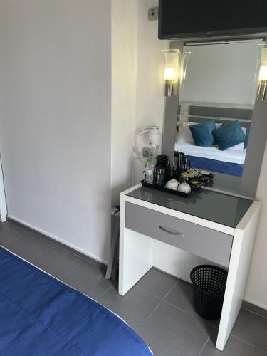 a room with a bed and a desk with a mirror at Αφροδίτη Hotel in Néon Rýsion