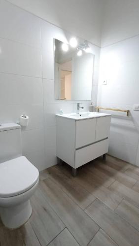 a bathroom with a toilet and a sink and a mirror at Casa Centenaria 1769 in Cubelles